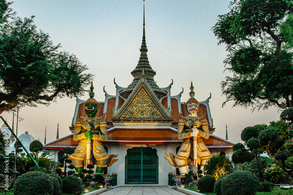 Ordination Hall next to Buddhist temple Wat Arun in Bangkok.Thailand landmark.Colorful porcelain statues.Sculptures of two mythical giant demons,temple guardian figures.Popular tourist destination.