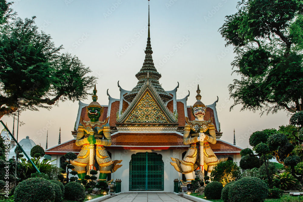Ordination Hall next to Buddhist temple Wat Arun in Bangkok.Thailand landmark.Colorful porcelain statues.Sculptures of two mythical giant demons,temple guardian figures.Popular tourist destination. Ordination Hall next to Buddhist temple Wat Arun in Bangkok.Thailand landmark.Colorful porcelain statues.Sculptures of two mythical giant demons,temple guardian figures.Popular tourist destination.