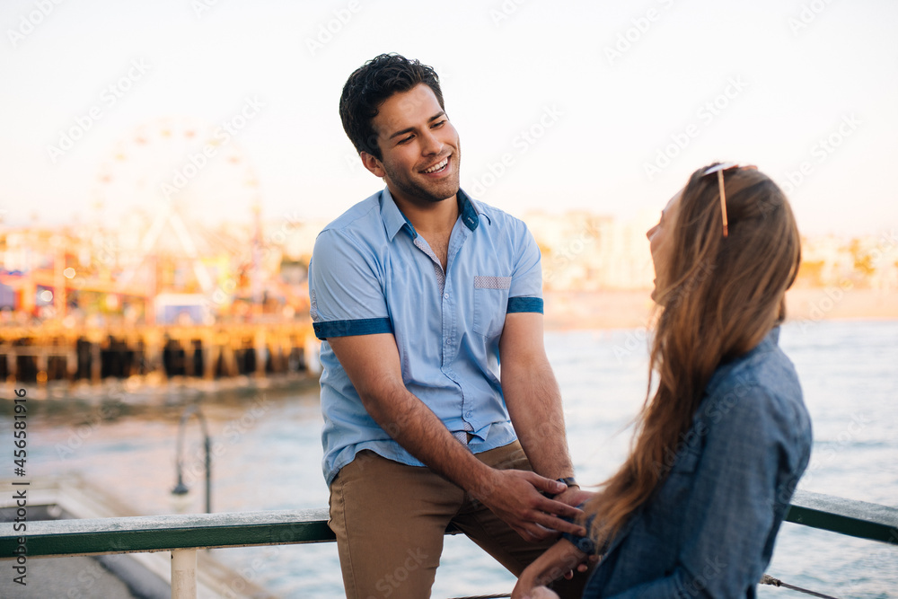 Young couple chatting on pier, Santa Monica, California, USA