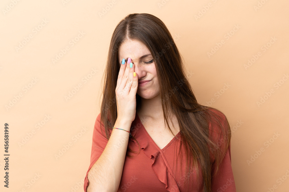 Young caucasian woman isolated on beige background with headache Young caucasian woman isolated on beige background with headache