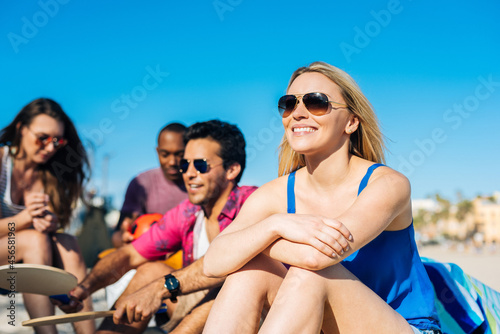 Four adult friends sitting on beach, Santa Monica, California, USA