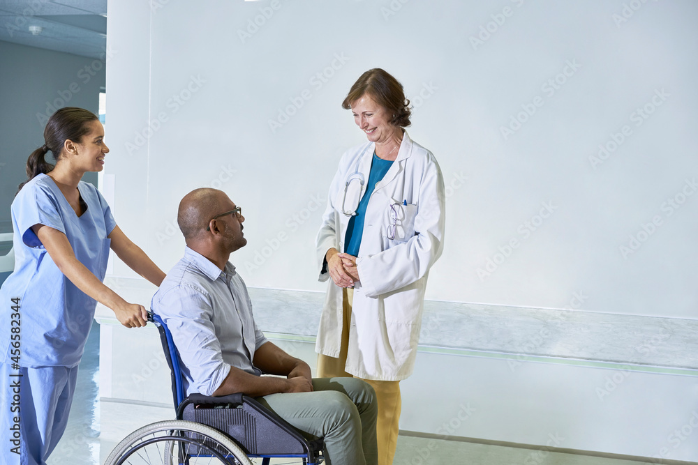 Obraz premium Doctor talking to man in wheelchair