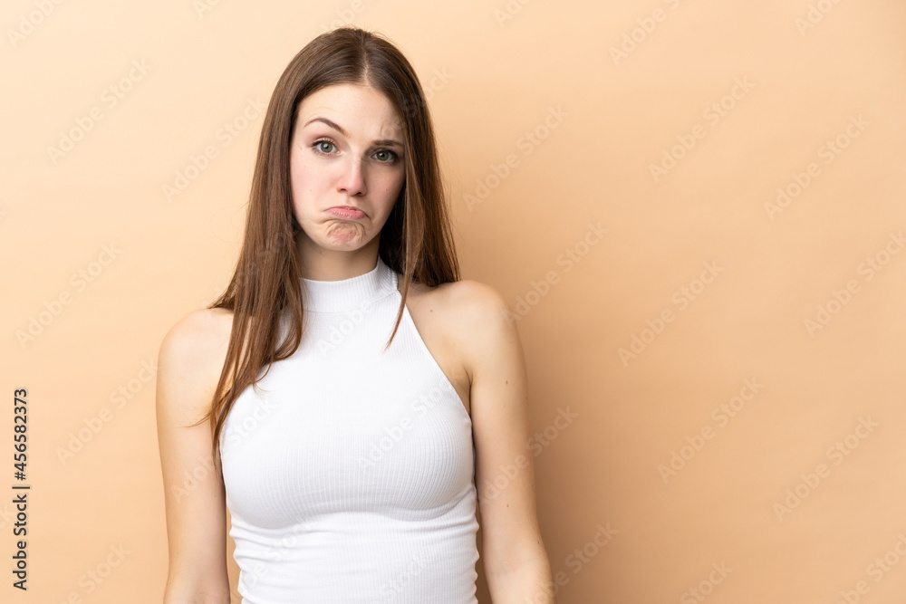 Young caucasian woman isolated on beige background with sad expression Young caucasian woman isolated on beige background with sad expression