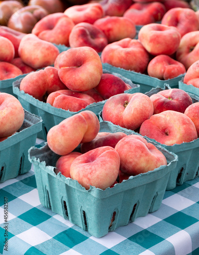 Cartons of doughnut peaches at an outdoor market photo