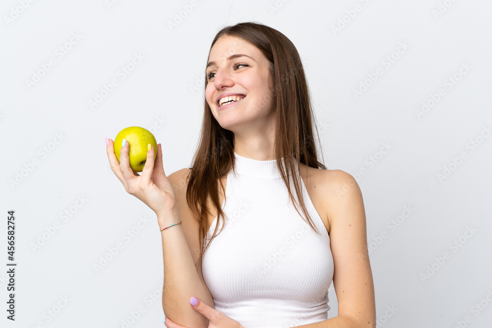 Young caucasian woman isolated on white background with an apple and happy Young caucasian woman isolated on white background with an apple and happy