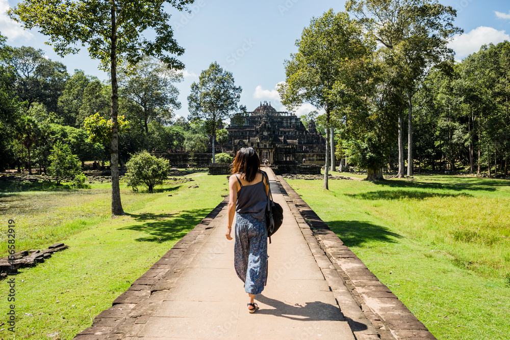 Naklejka premium Rear view of woman in garden of Phimeanakas temple, Siem Reap, Cambodia