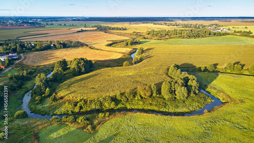 Farmland Corn harvest. September agriculture fields aerial panorama. Sunny autumn landscape. Meadows, river, village