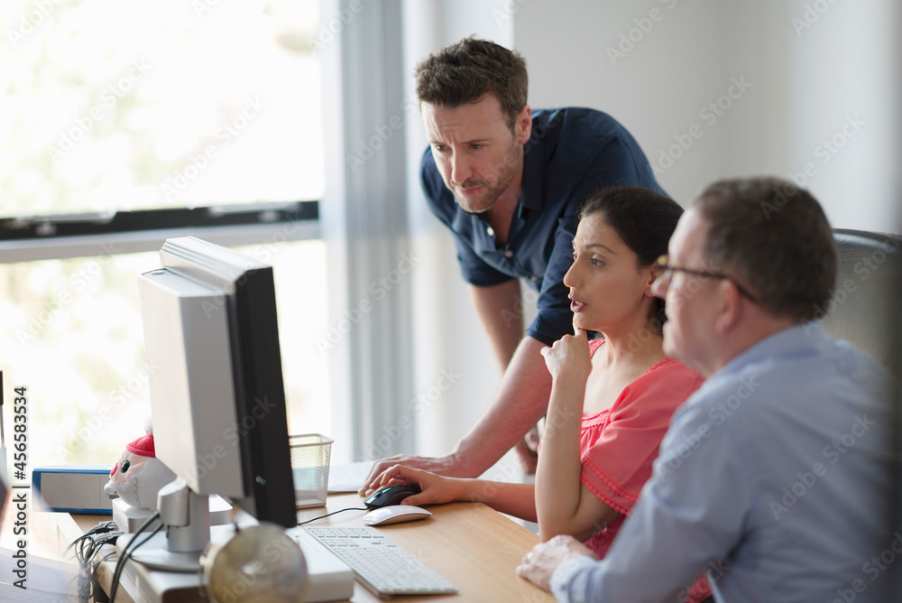 Colleagues in discussion at office desk Colleagues in discussion at office desk