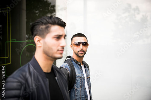 Two male friends  walking in street