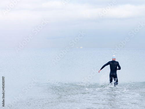 Rear view of man in wet suit and swimming cap in sea, Melbourne, Victoria, Australia, Oceania © Cultura Allies