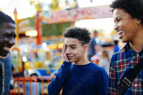 Three boys at funfair, laughing