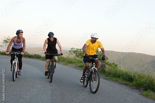 Fototapeta Naklejka Na Ścianę i Meble -  Three cyclists on the road