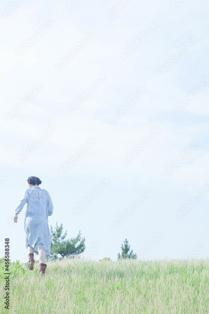 Young woman walking in field, rear view