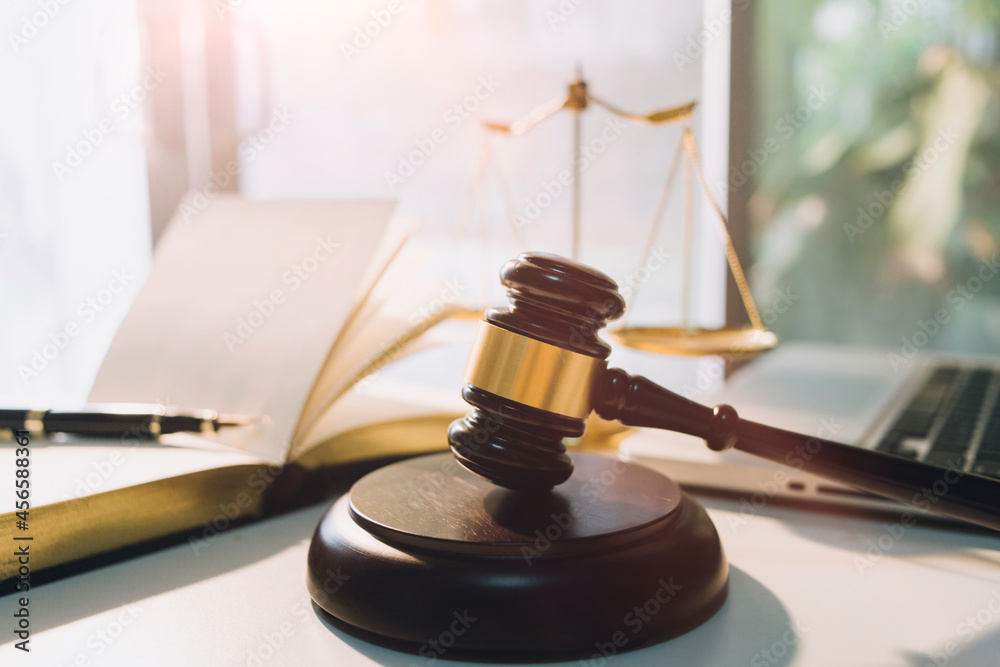 Business and lawyers discussing contract papers with brass scale on desk in office. Law, legal services, advice, justice and law concept