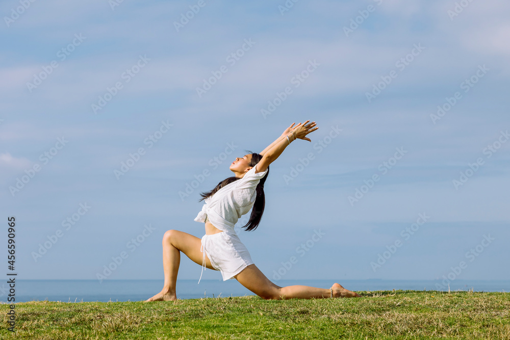Asian woman performing Crescent Lunge pose on yoga mat Asian woman performing Crescent Lunge pose on yoga mat