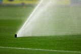 Details with lawn sprinklers on the pitch of a soccer stadium.
