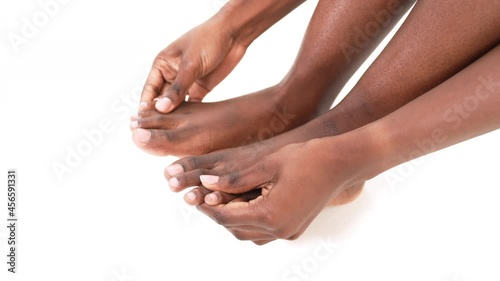 Wallpaper Mural Close up of an African woman's hands massaging her toes and feet. Isolated on a white background. Torontodigital.ca