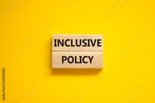 Inclusive policy symbol. Wooden blocks with words Inclusive policy on beautiful yellow background. Business, HR and inclusive policy concept. Copy space. photo