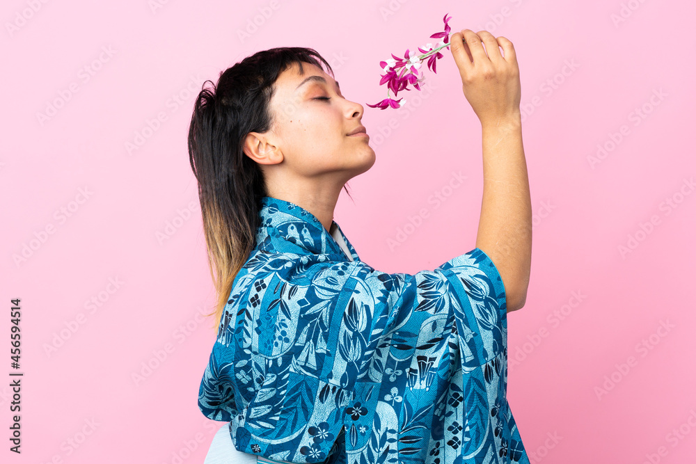 Young woman wearing kimono over isolated pink background Young woman wearing kimono over isolated pink background
