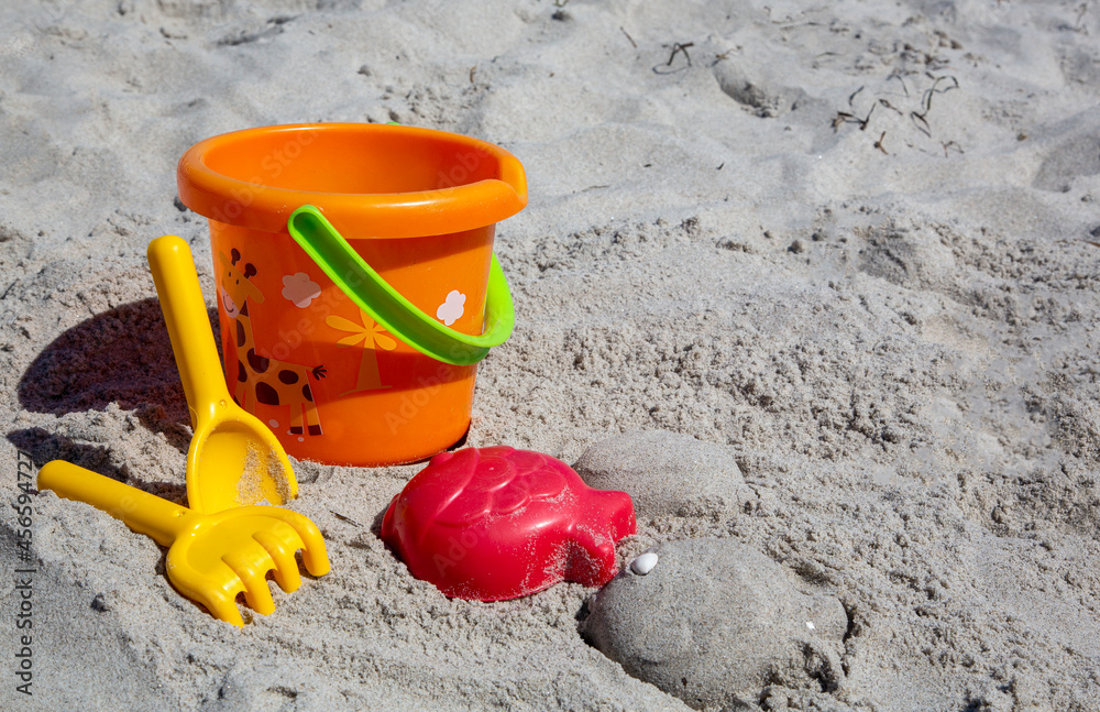 Colorful plastic toys in the sand of a beach Colorful plastic toys in the sand of a beach