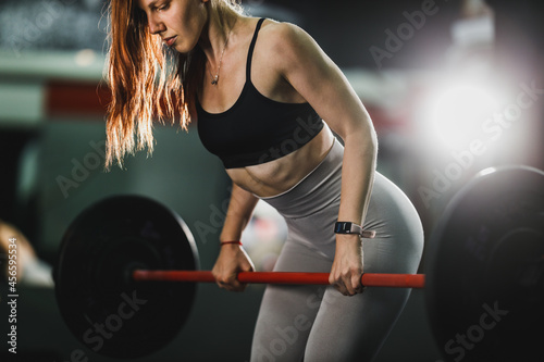 Muscular Woman Doing Back Training With Barbell At The Gym