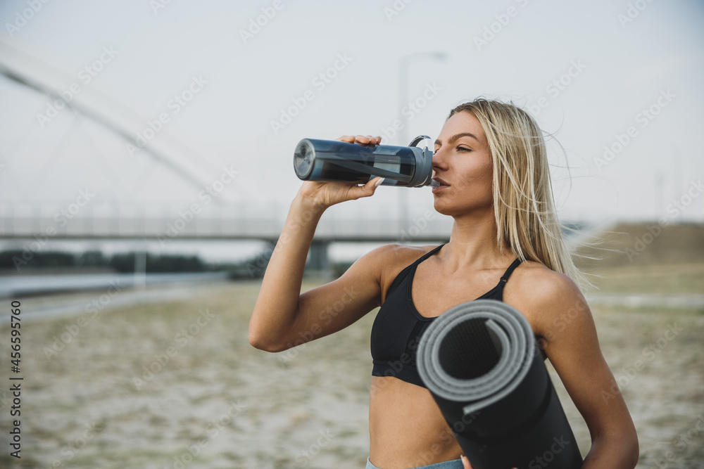 Woman Take A Break And Drinking Water During Outdoor Working Out