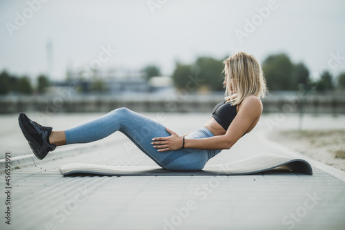 Young Fit Woman Doing Sit Ups During Working Up Outdoors photo