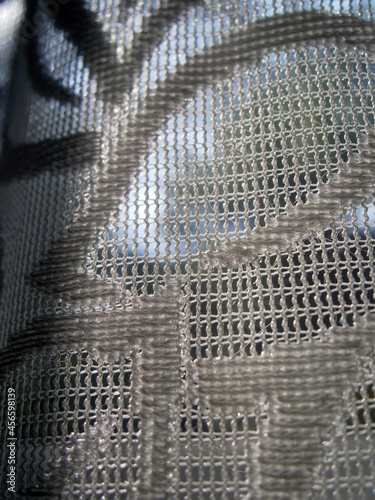 Net tulle on the window in the sun