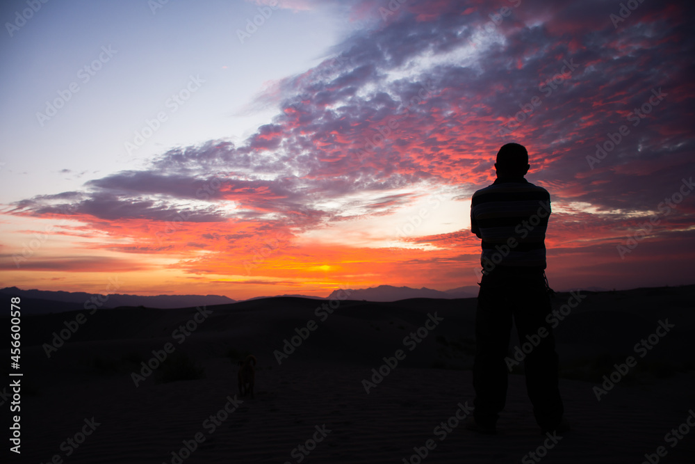 Unrecognizable man looking the sunrise at the desert Unrecognizable man looking the sunrise at the desert
