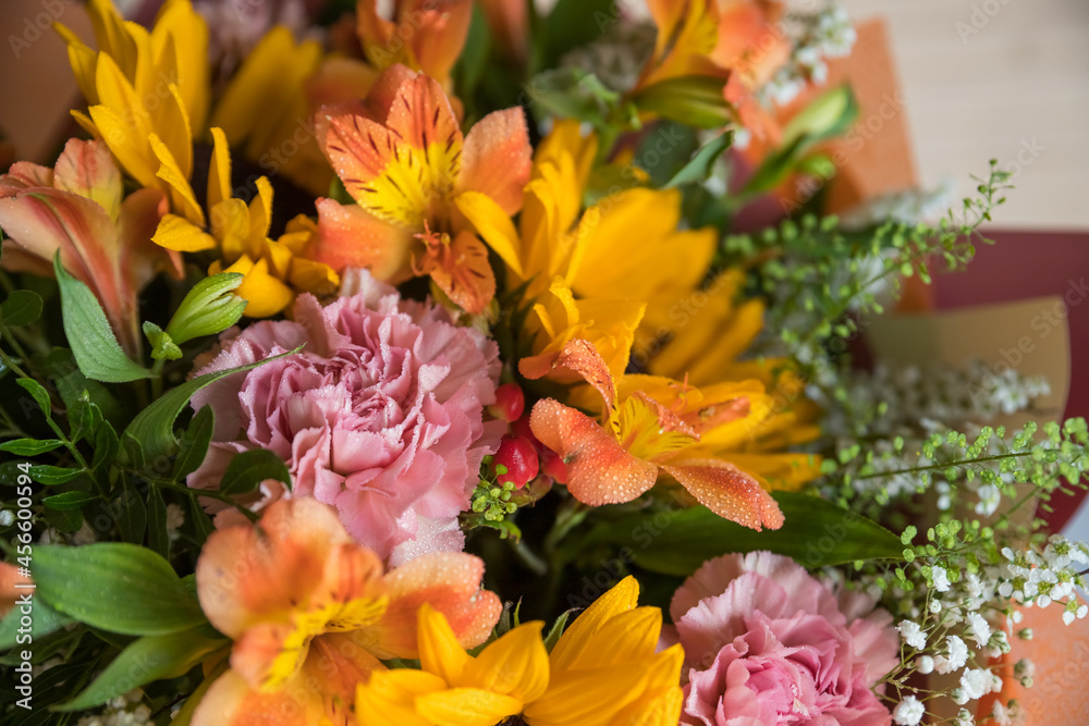 Fresh Bouquet of yellow sunflowers and pink carnations on marble background. flower shop. A variant of a bouquet on an autumn theme, for Thanksgiving.