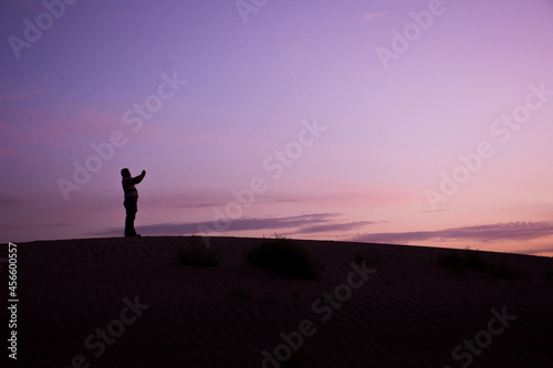 Silhouette of a man on a dune at sunset
