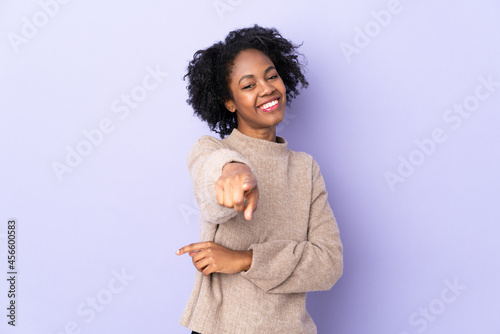 Young African American woman isolated on purple background pointing front with happy expression