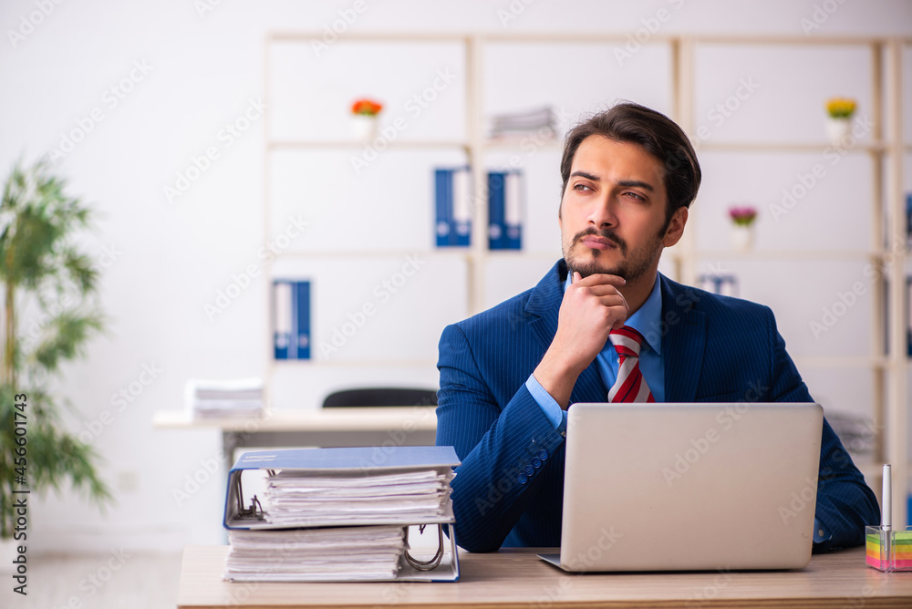 Young male employee sitting at workplace Young male employee sitting at workplace