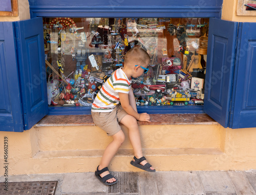 The little boy sees vintage toys in a shop window © Marina