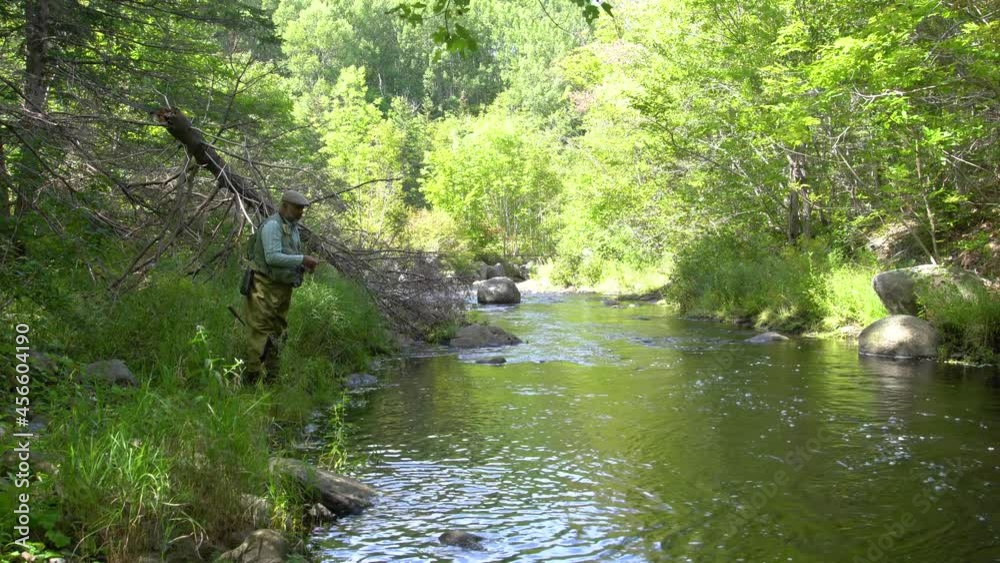 A mature fly-fisherman on a trout stream in the early autumn A mature fly-fisherman on a trout stream in the early autumn