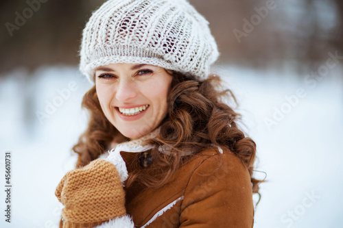 smiling elegant female outside in city park in winter