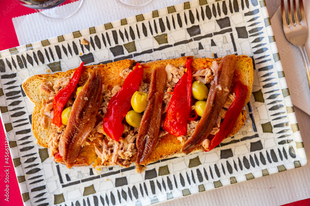 Foto de Appetizing spanish sandwich with anchovy and baked bell pepper