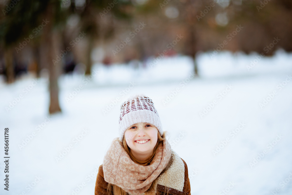 happy stylish girl outdoors in city park in winter playing