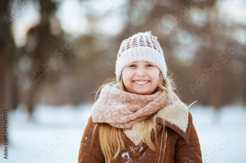 smiling stylish child outside in city park in winter