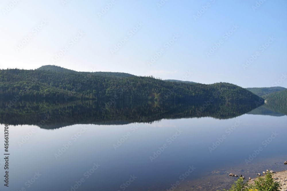 Lake Résimond, Quebec, Canada: View of perfectly still morning reflections on the lake Lake Résimond, Quebec, Canada: View of perfectly still morning reflections on the lake