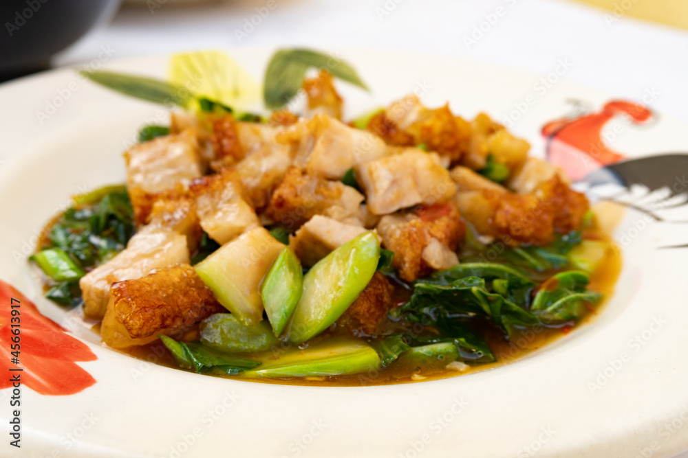 Selective Focus Stir fried chinese kale with crispy pork on red table Selective Focus Stir fried chinese kale with crispy pork on red table