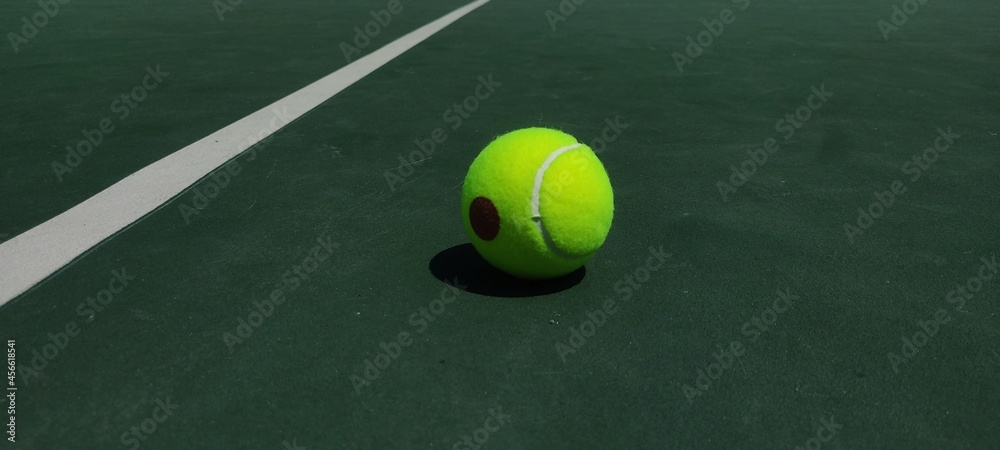 Pelota de tenis cae después de que un jugador anotara un punto. El entrenador de tenis mencionó el puntaje de los jugadores. Pelota de tenis en medio de la pista de tenis.