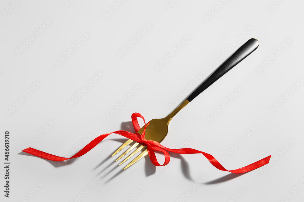 Fork with stylish ribbon on light background Fork with stylish ribbon on light background