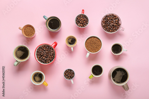 Different cups with coffee and beans on color background