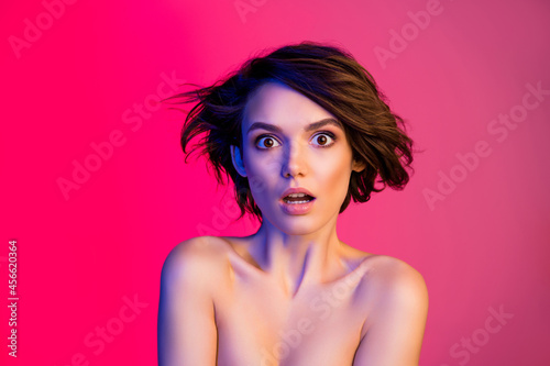 Portrait of attractive amazed glamorous girl sale news reaction air blowing hair isolated over bright lilac multicolor color background photo