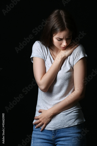 Scared young woman on dark ...