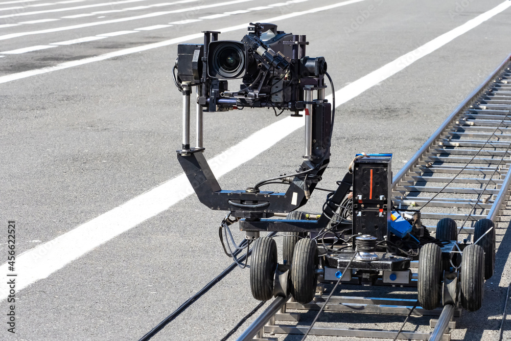 A trolley with video camera on rails. Camera trolley with camera.  Cinematography equipment. Concept - rent of operator equipment. Equipment  for video filming. Rail trolley for operator. foto de Stock | Adobe Stock
