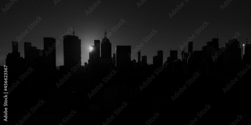 Melbourne city skyline silhouetted by a dramatic sunset in black and white