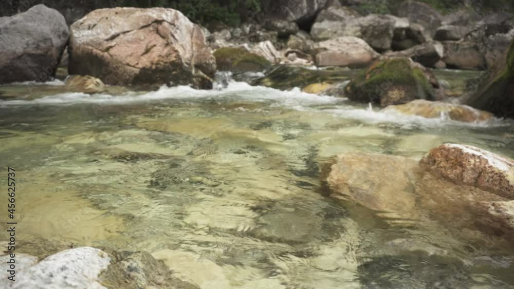 Clear mountain river water flowing through rocky boulder, static shot Clear mountain river water flowing through rocky boulder, static shot