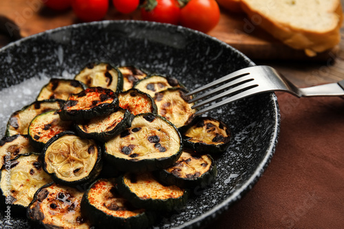 Plate with tasty grilled zucchini on wooden background, closeup